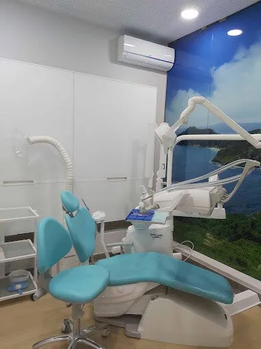 Gabinete de Clínica Dental Seijo con sillón dental turquesa y mural de paisaje marino