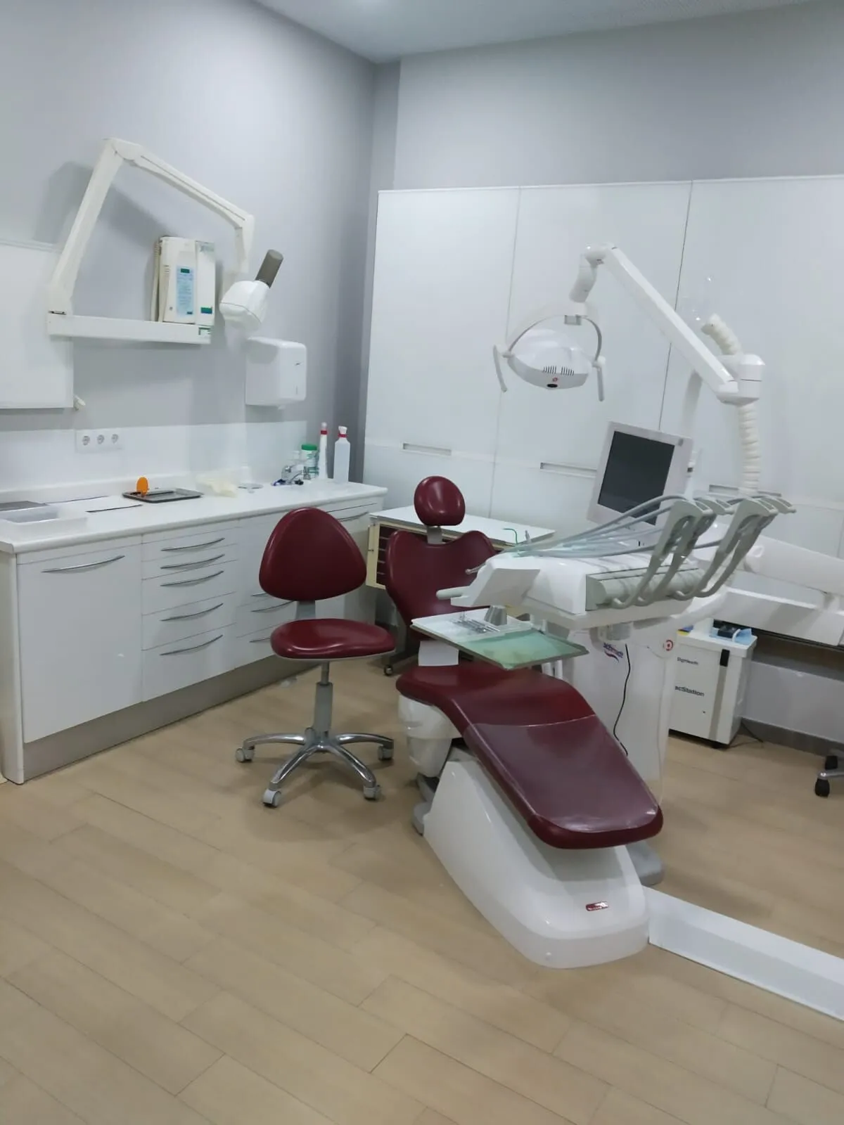 Gabinete de Clínica Dental Seijo con sillón granate, lámpara y equipo de rayos X
